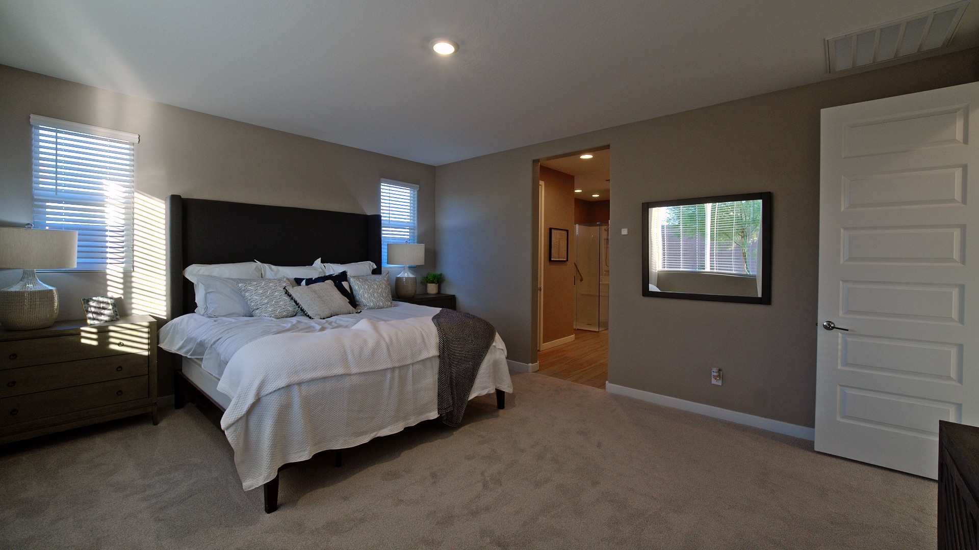 Staged bedroom with natural light and neutral finishes